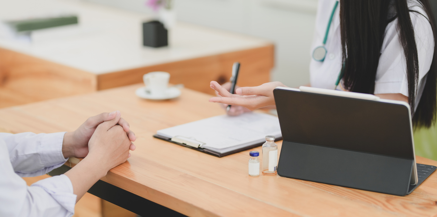 Crop female doctor consulting patient in clinic